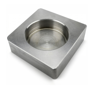 A precision-machined square steel block with a circular recessed cavity, showing visible concentric tool marks from a milling or turning process, isolated on a white background.
